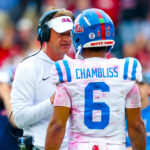 Lane Kiffin talks with quarterback Trinidad Chambliss.